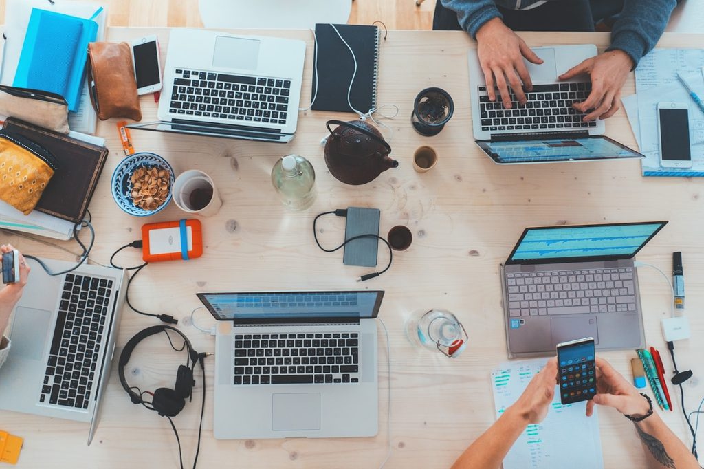 Flere personer arbejder ved computere omkring et bord
